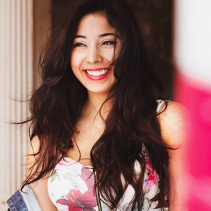 Young woman with long dark wavy hair, and flower print dress